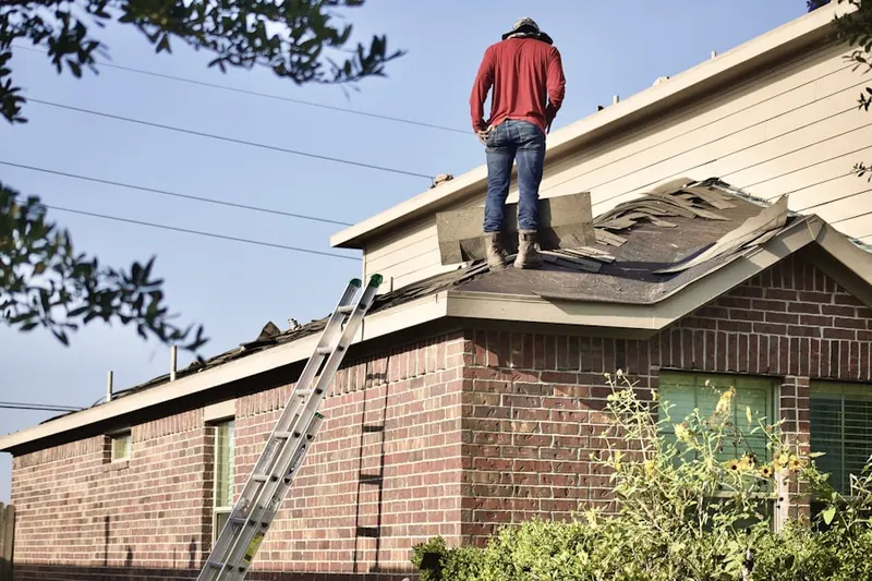 Professional roofer working on a residential roof in Chelsea at Mission Bend